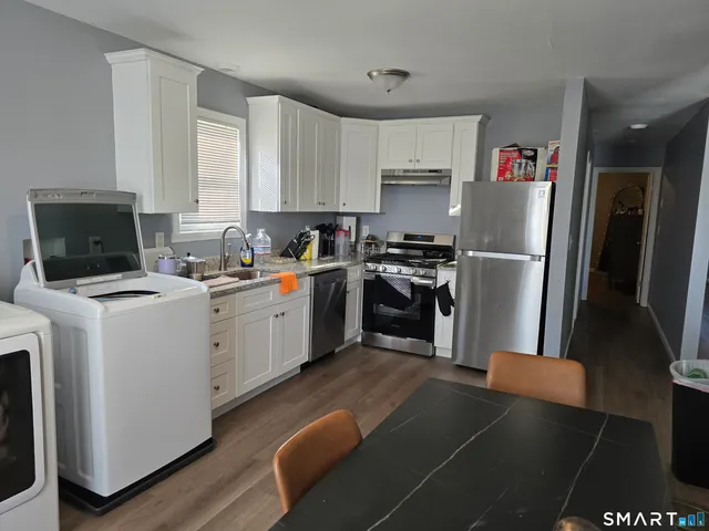 a kitchen with a refrigerator a stove top oven a sink and cabinets