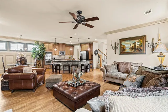 a kitchen with stainless steel appliances granite countertop a stove top oven a refrigerator a sink and chairs