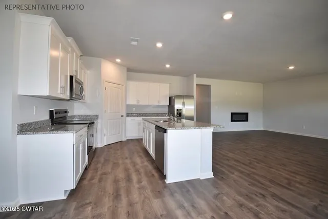 a kitchen with kitchen island white cabinets and stainless steel appliances
