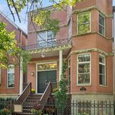 a front view of a house with a tree