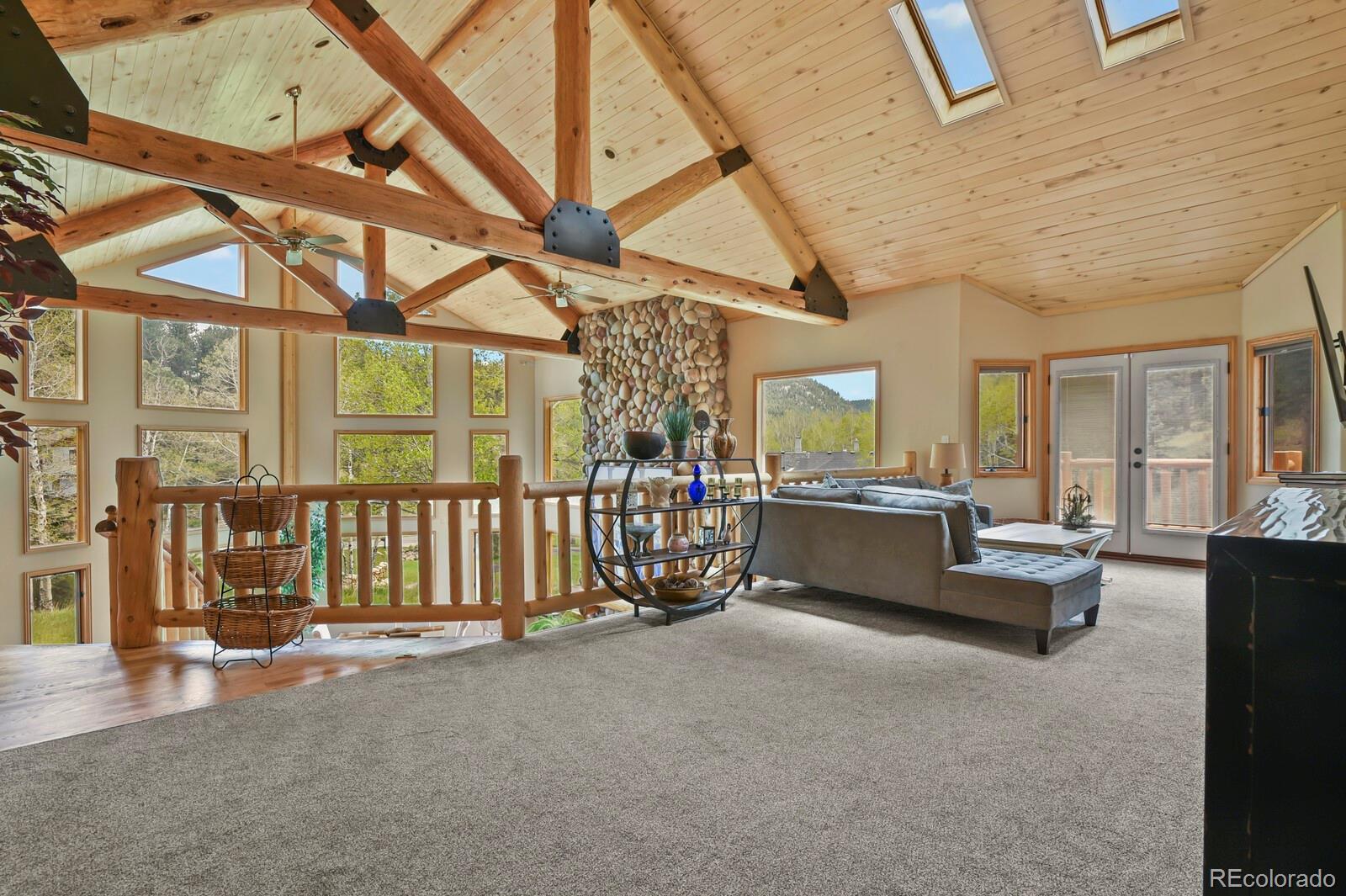 417 Witter Gulch Road Evergreen, CO 80439 - Photo 28 of 50 a living room with furniture and a chandelier