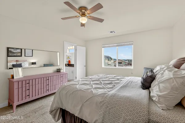 a bedroom with a bed chandelier and a window