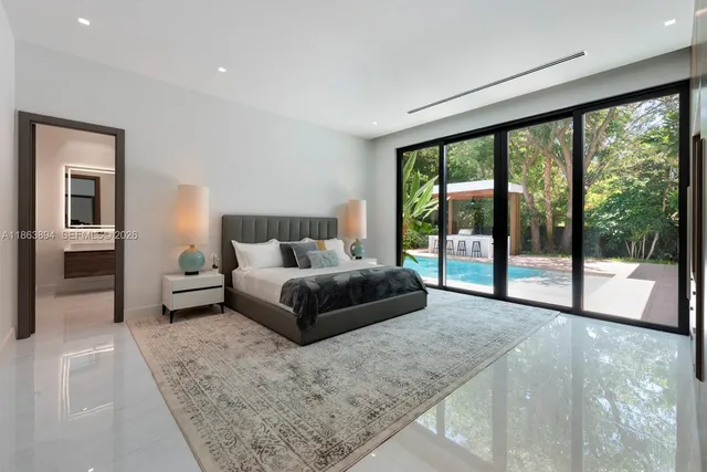 a large bed sitting in a bedroom next to a window