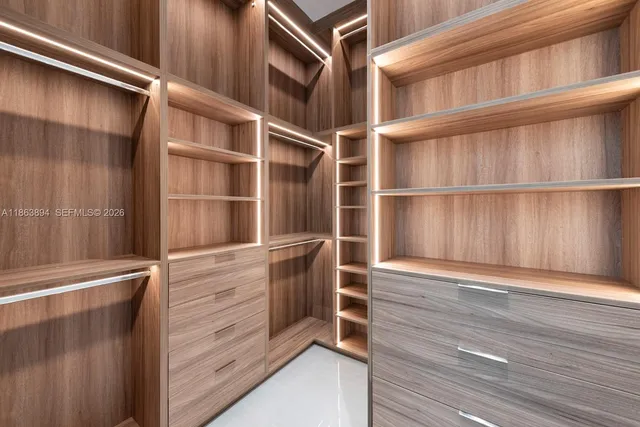 a spacious bedroom with a bed and chair