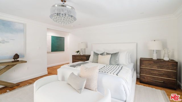 a bedroom with a bed and a chandelier