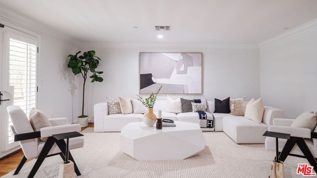 a living room with furniture and a potted plant
