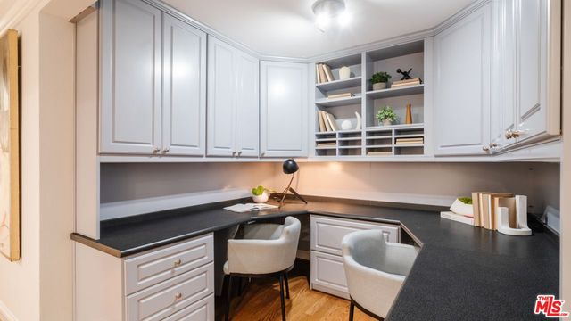 a kitchen that has a sink and a stove with wooden floor