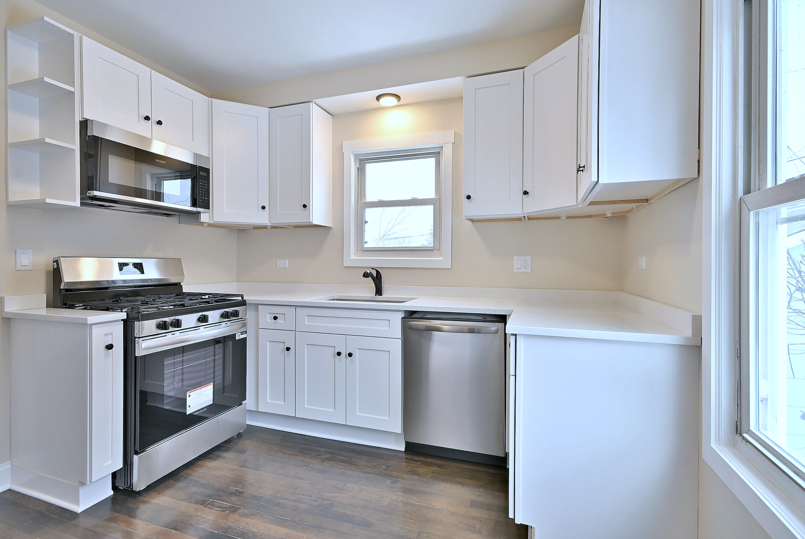 9016 Southview Avenue Brookfield, IL 60513 - Photo 24 of 45 a kitchen with stainless steel appliances granite countertop white cabinets a sink a stove a microwave and a window