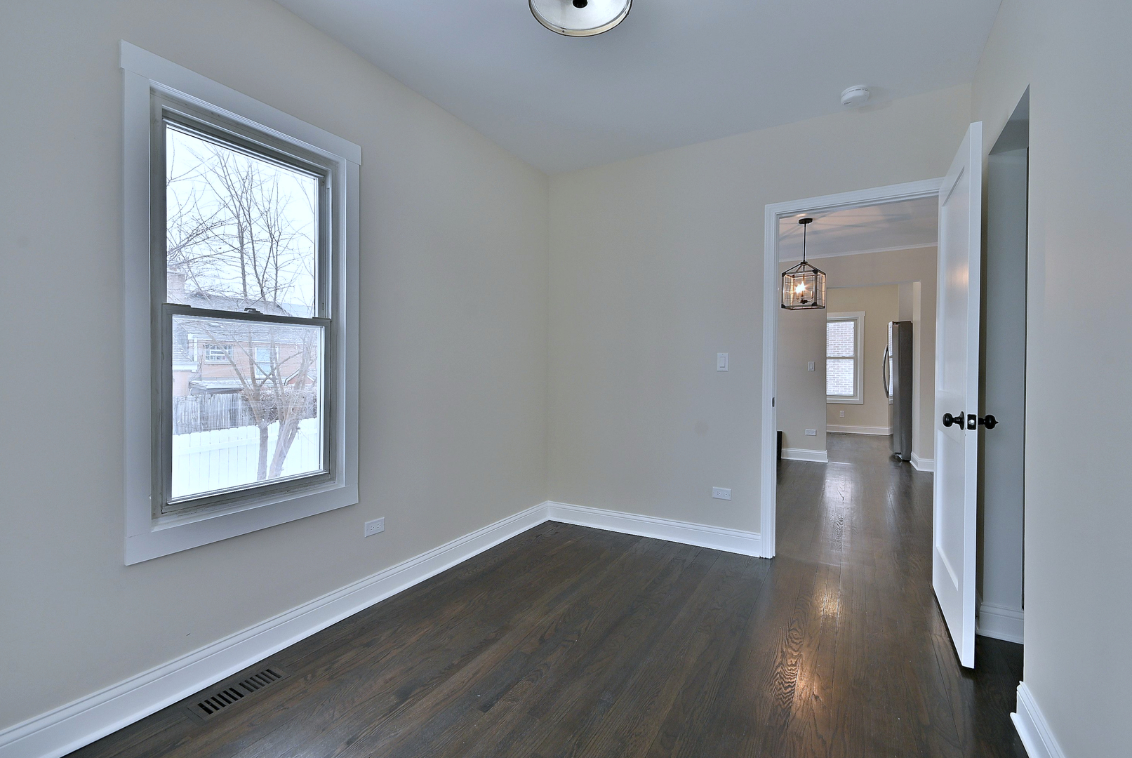 9016 Southview Avenue Brookfield, IL 60513 - Photo 27 of 45 a view of an empty room with wooden floor and a window