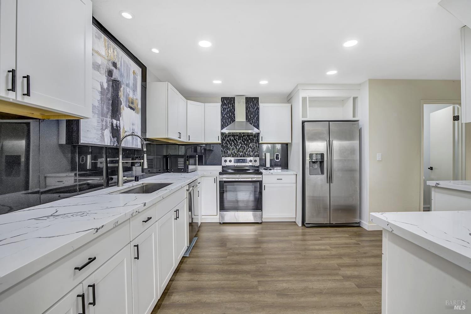 870 Hudis Street Rohnert Park, CA 94928 - Photo 3 of 49 a large kitchen with stainless steel appliances kitchen island granite countertop a refrigerator and a stove top oven