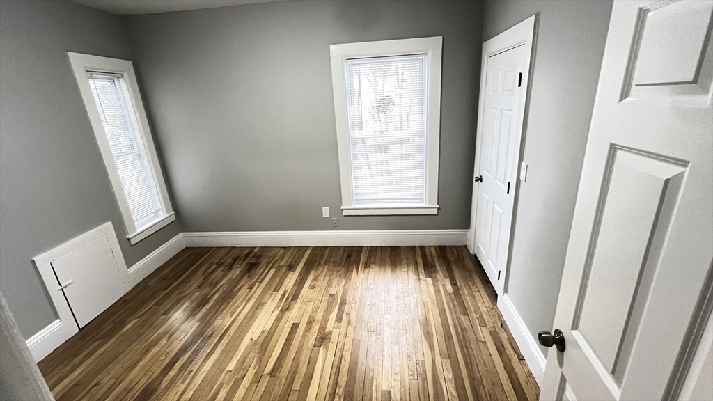 31 Ridgeway Street, Unit 1 Lynn, MA 01902 - Photo 7 of 16 a view of an empty room with wooden floor and a window