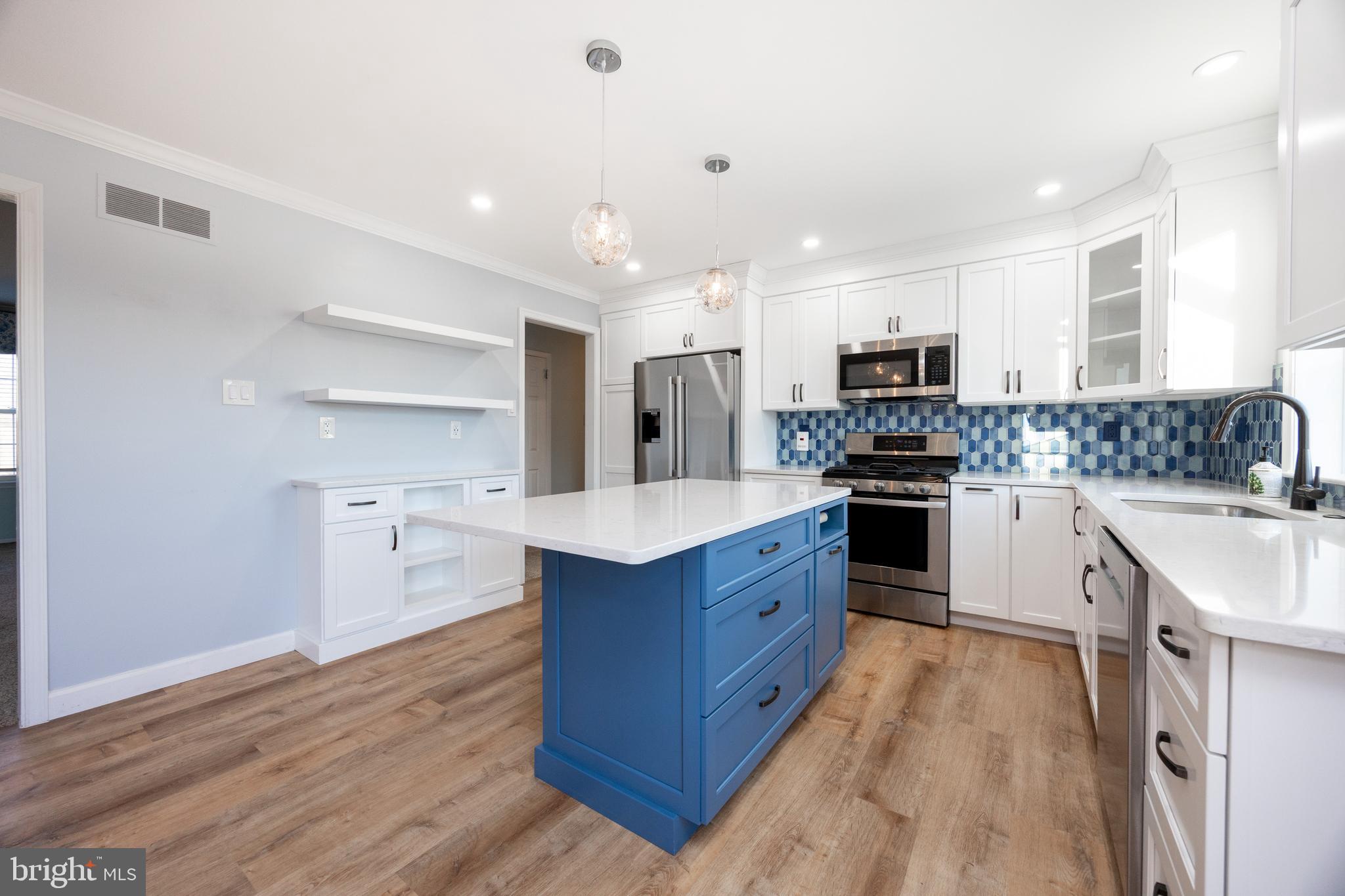 5 Cheyenne Road Royersford, PA 19468 - Photo 13 of 29 a kitchen with stainless steel appliances granite countertop a stove top oven a sink dishwasher and a refrigerator with wooden floor