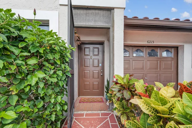 a view of a house with a yard and potted plants