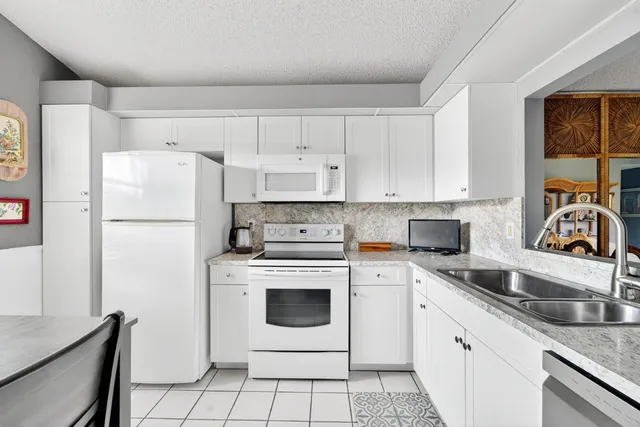 a kitchen with white cabinets sink and white appliances