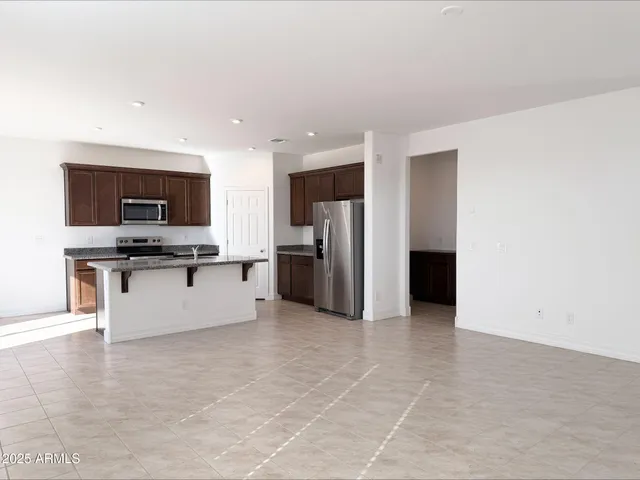 a large kitchen with stainless steel appliances a refrigerator and a stove top oven