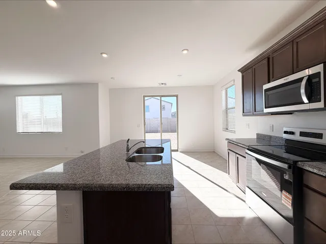 a kitchen with stainless steel appliances granite countertop a sink and a stove