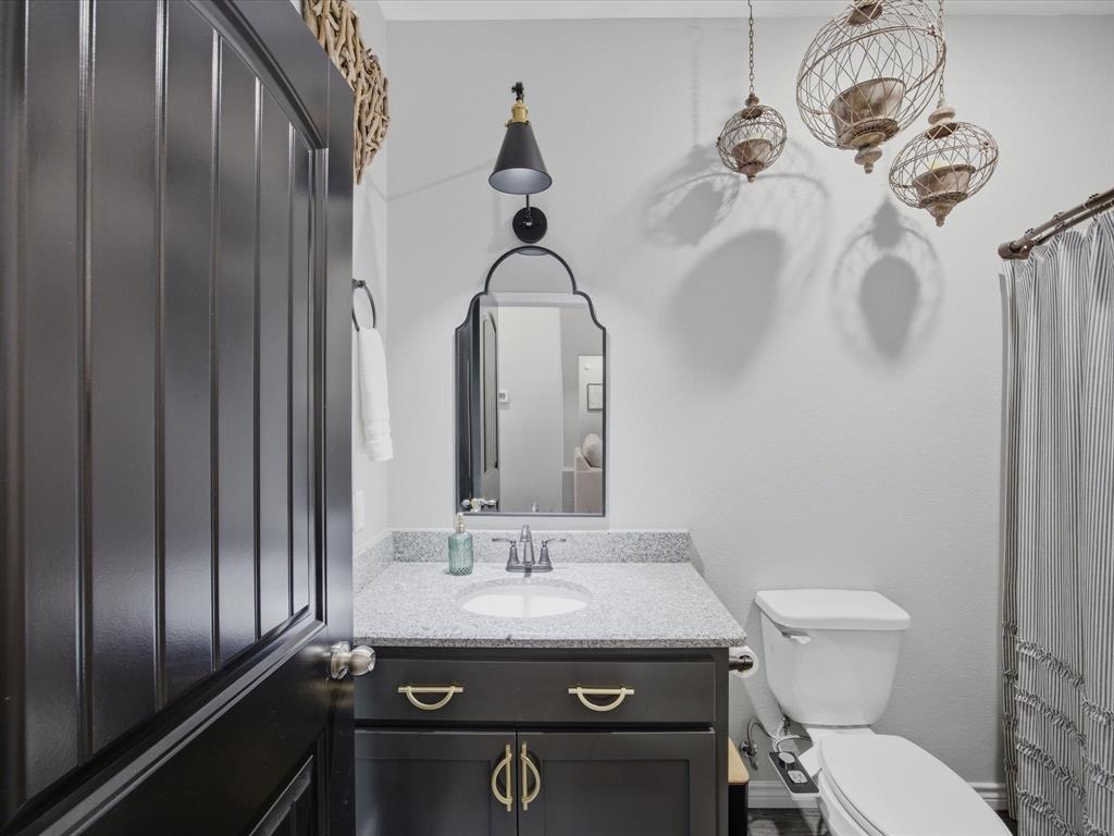 117 Ranchview Court Bowie, TX 76230 - Photo 20 of 40 a bathroom with a granite countertop sink a toilet and a mirror