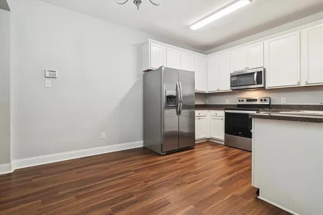 a kitchen with wooden floors and stainless steel appliances