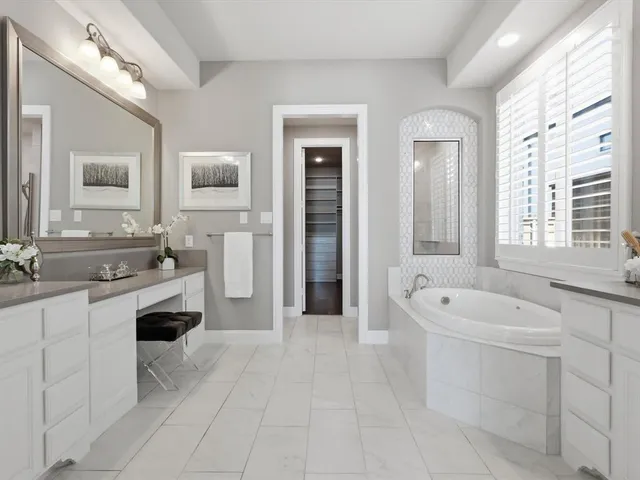 a spacious bathroom with a tub sink and mirror