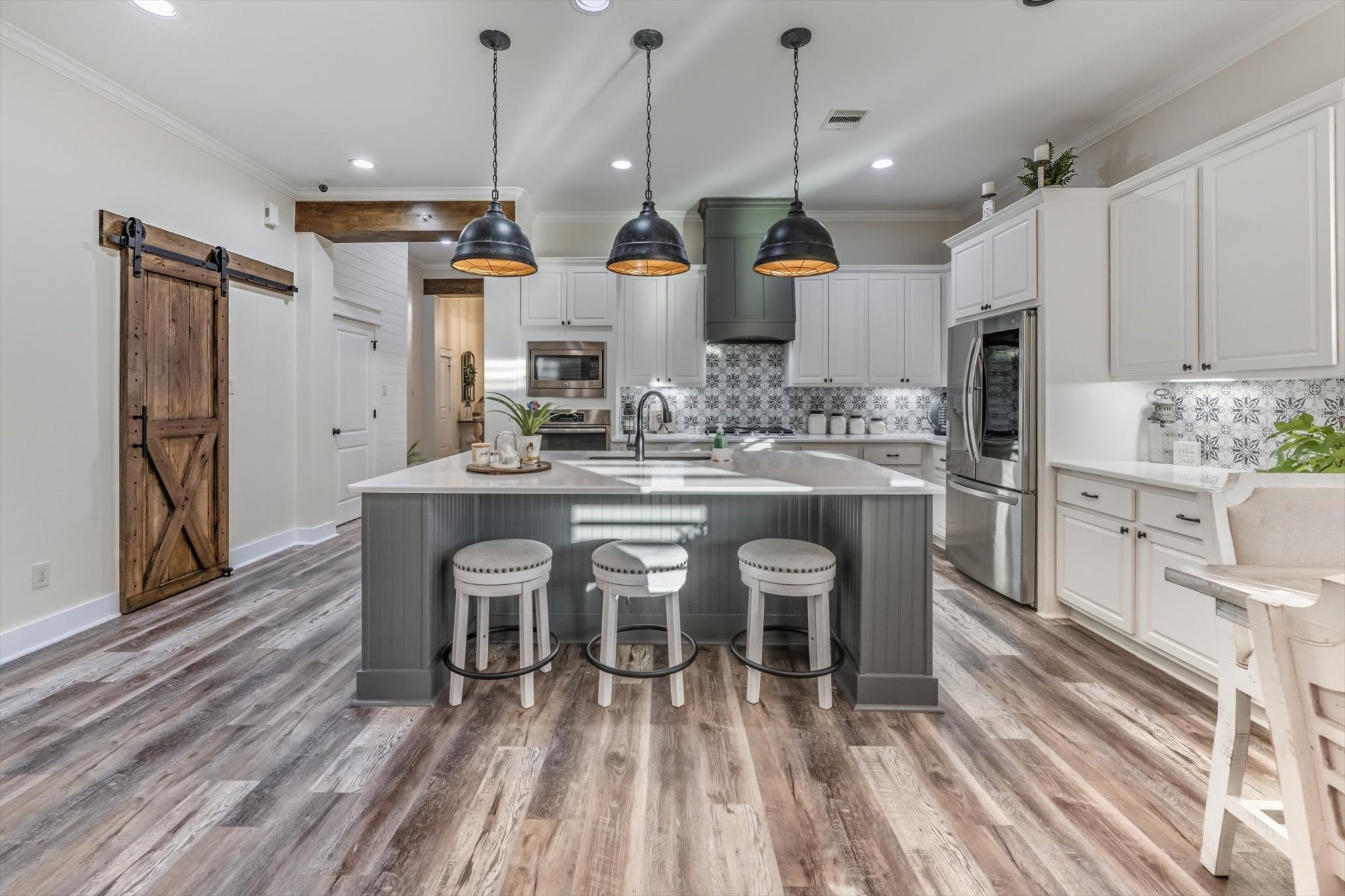 103 Fox Rindle Road Montgomery, TX 77316 - Photo 3 of 44 A chef’s kitchen designed to impress, showcasing a grand quartz island, designer lighting, and custom finishes throughout. Thoughtfully crafted for both elevated entertaining and everyday luxury.