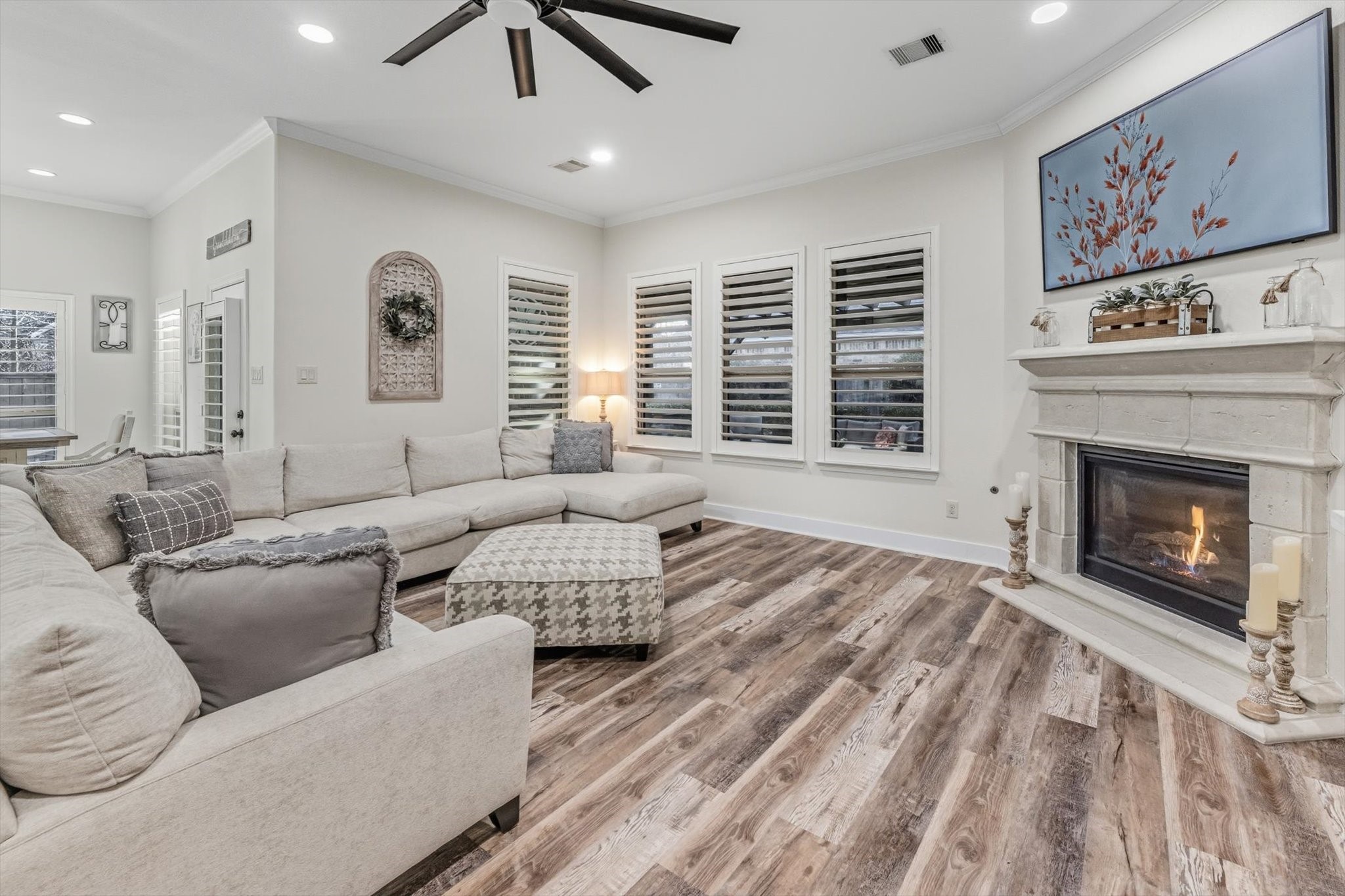 103 Fox Rindle Road Montgomery, TX 77316 - Photo 9 of 44 Expansive windows with plantation shutters line the living area, filling the space with natural light and showcasing serene backyard views.
