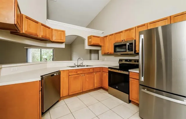 a kitchen with stainless steel appliances granite countertop a refrigerator and a stove top oven
