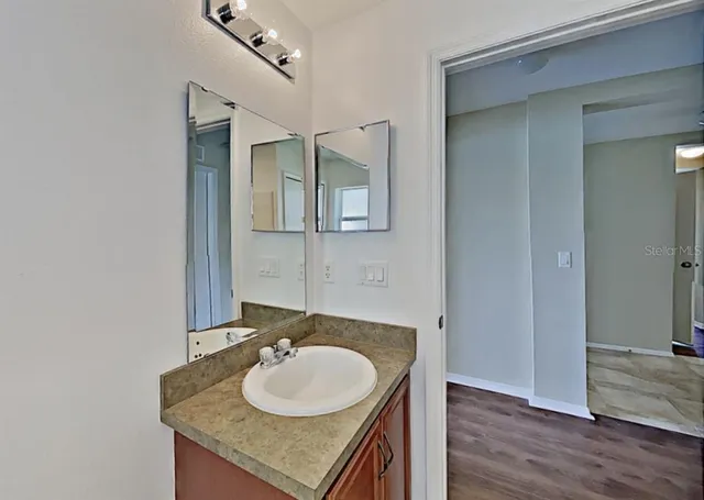 a bathroom with a granite countertop sink and a mirror