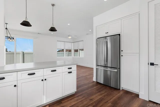 a kitchen with stainless steel appliances a refrigerator and wooden floor