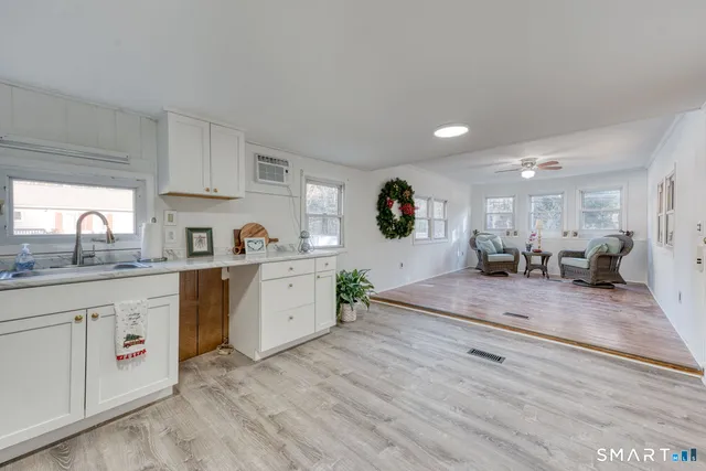 a kitchen with granite countertop white cabinets and white stainless steel appliances
