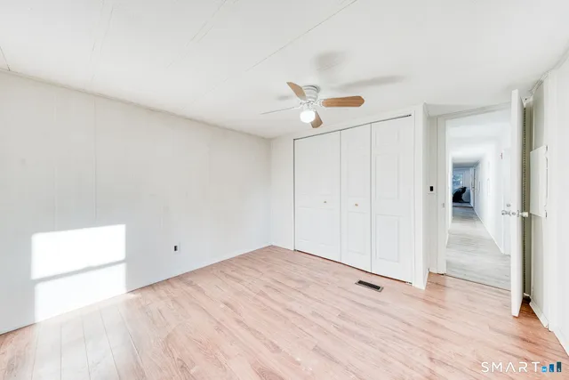 a view of a big room with wooden floor and windows