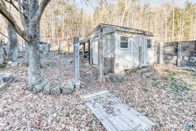 a view of a house with a yard and large tree