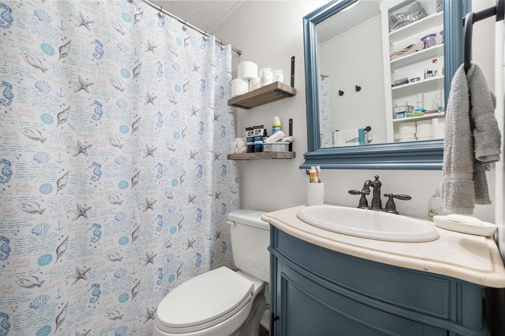 1704 Joyce Street Arlington, TX 76010 - Photo 14 of 19 a bathroom with a sink a toilet and a mirror