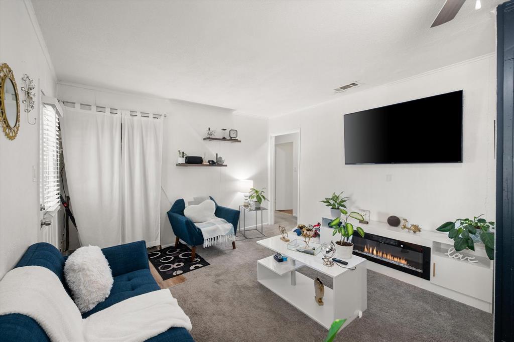1704 Joyce Street Arlington, TX 76010 - Photo 4 of 19 a living room with furniture a flat screen tv and a potted plant