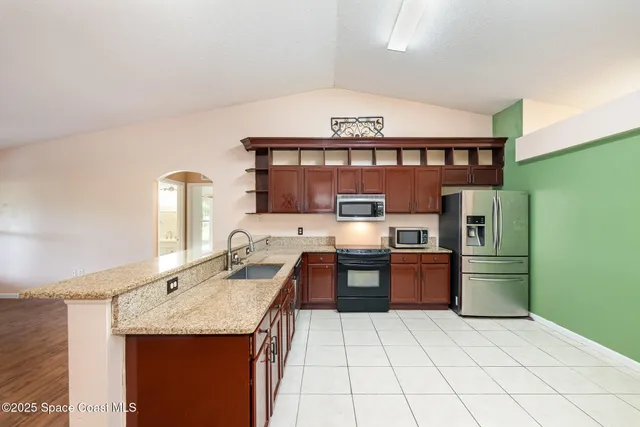 a kitchen with stainless steel appliances granite countertop a sink stove and refrigerator