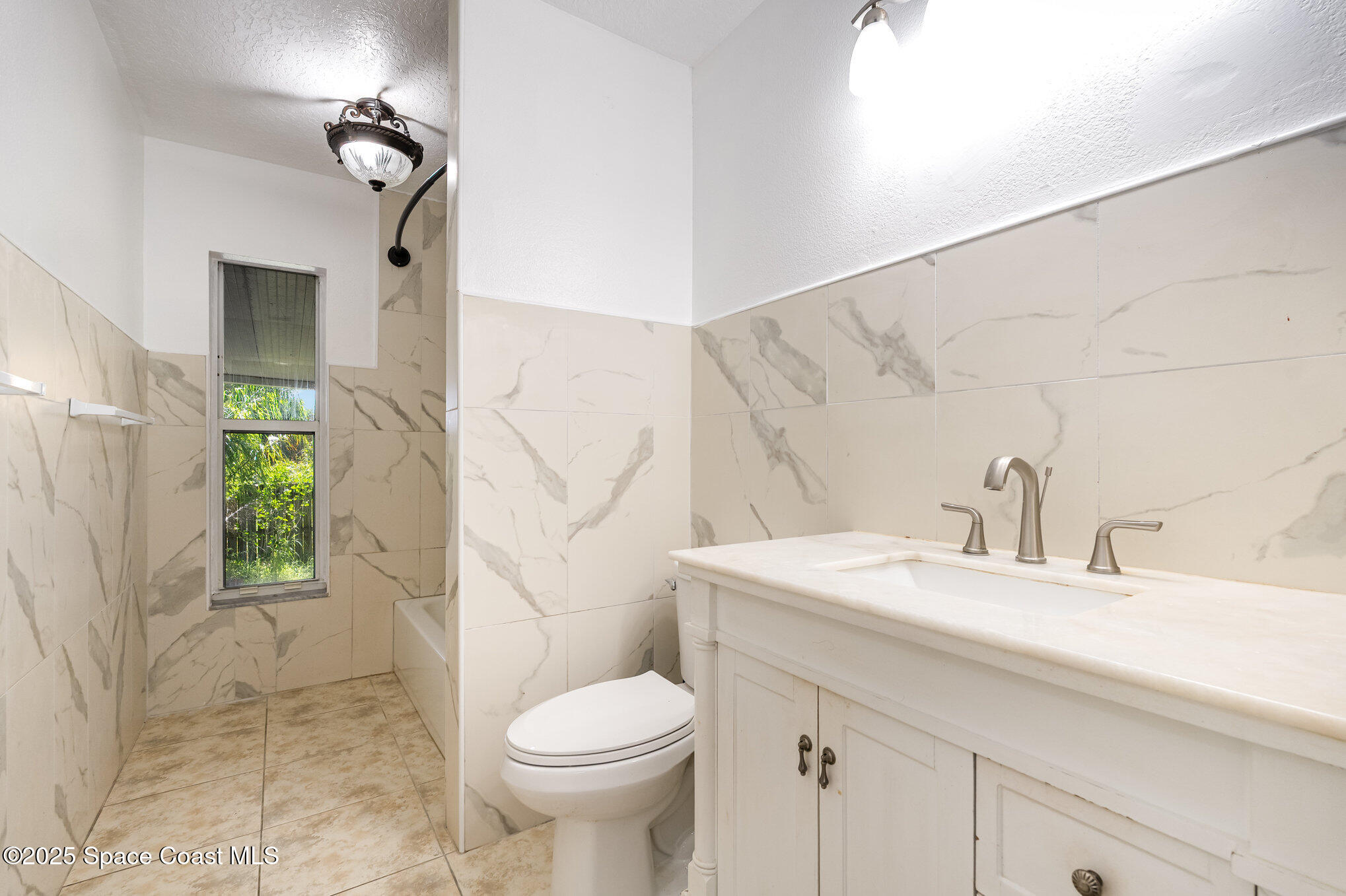 6105 Banyan Street Cocoa, FL 32927 - Photo 21 of 27 a bathroom with a sink a toilet and shower