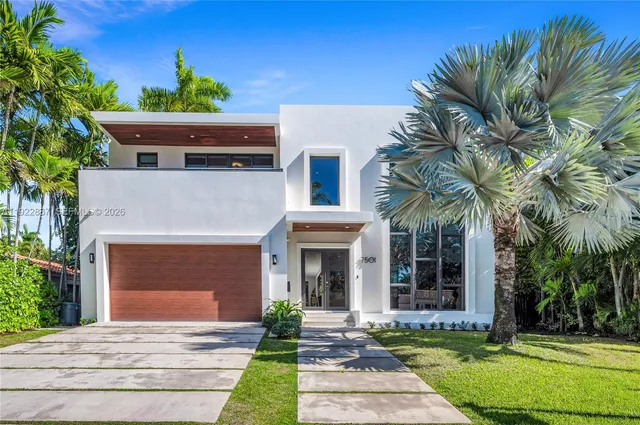 a front view of a house with yard and tress