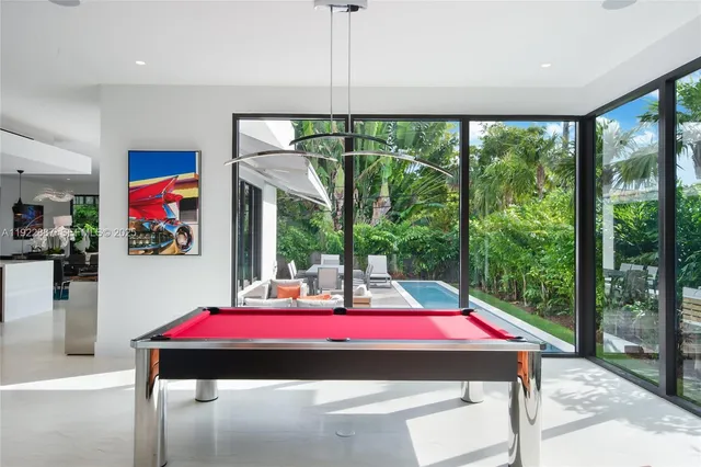 a room with pool table and windows