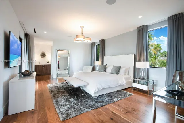 a spacious bedroom with a bed window and table chair