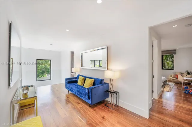 a living room with furniture and a wooden floor