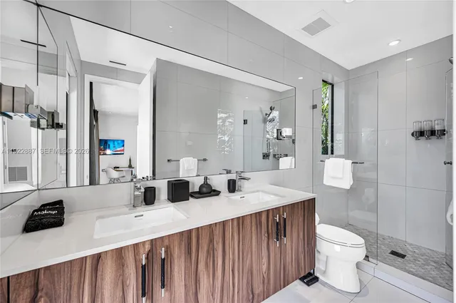 a bathroom with a toilet sink mirror and vanity