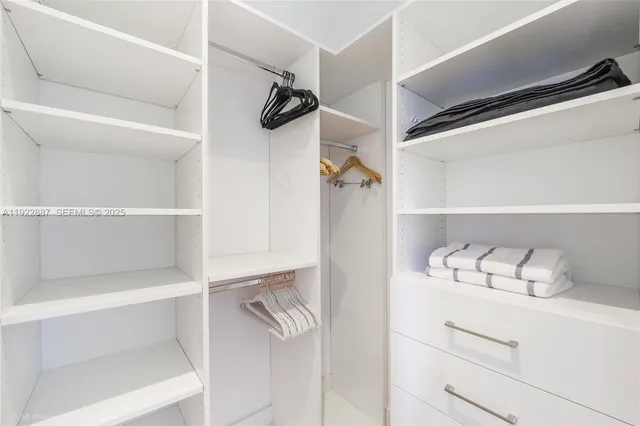 a view of walk in closet with empty racks