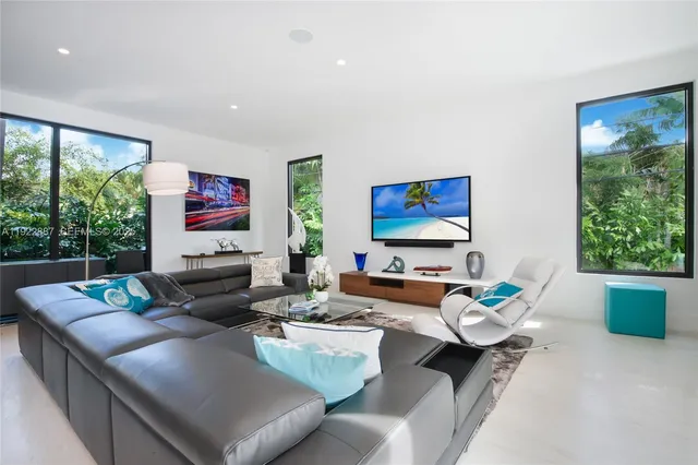 a living room with furniture potted plant and a large window