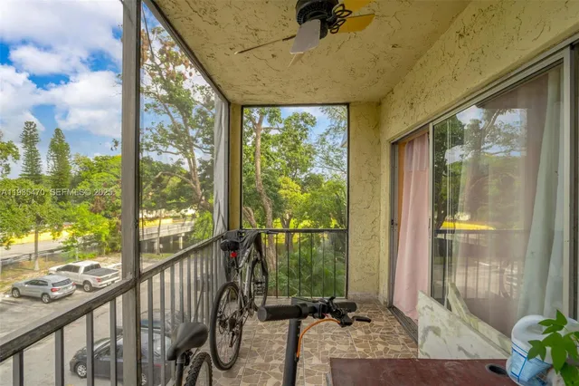 a view of a porch with a floor to ceiling window and wooden floor