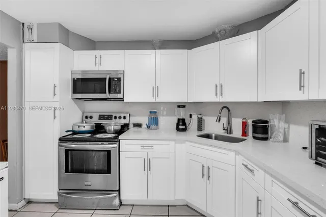 a kitchen with cabinets stainless steel appliances and a sink