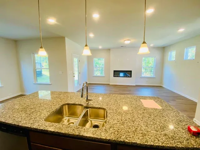 a bathroom with a tub a sink and a wooden floor