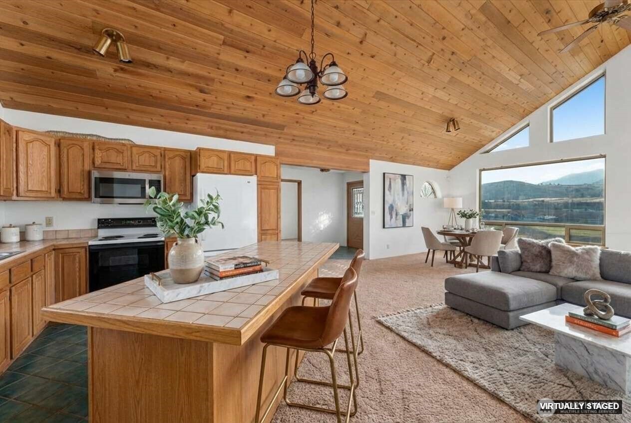 11 Pateros Fish Hatchery Road Pateros, WA 98846 - Photo 12 of 33 a kitchen with stainless steel appliances granite countertop a stove a sink dishwasher a dining table and chairs with wooden floor