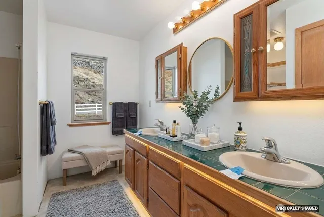 a bathroom with a granite countertop sink and a mirror
