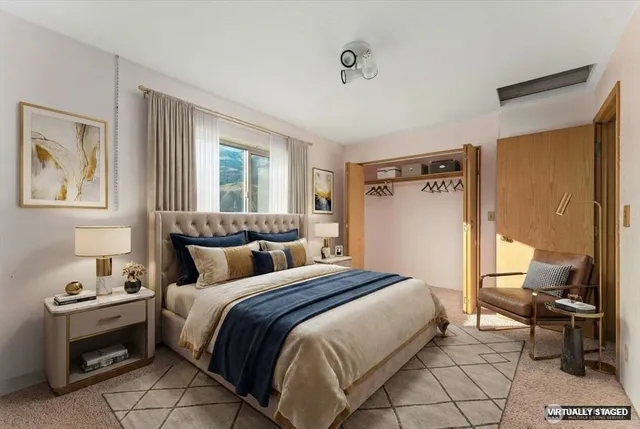 a bedroom with a bed and a lamp on dresser