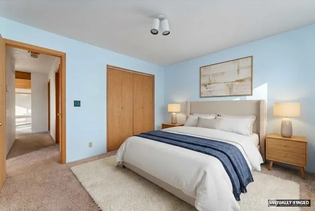 a bedroom with a bed and a painting on the wall