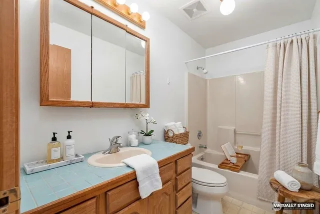 a bathroom with a granite countertop sink mirror vanity and toilet